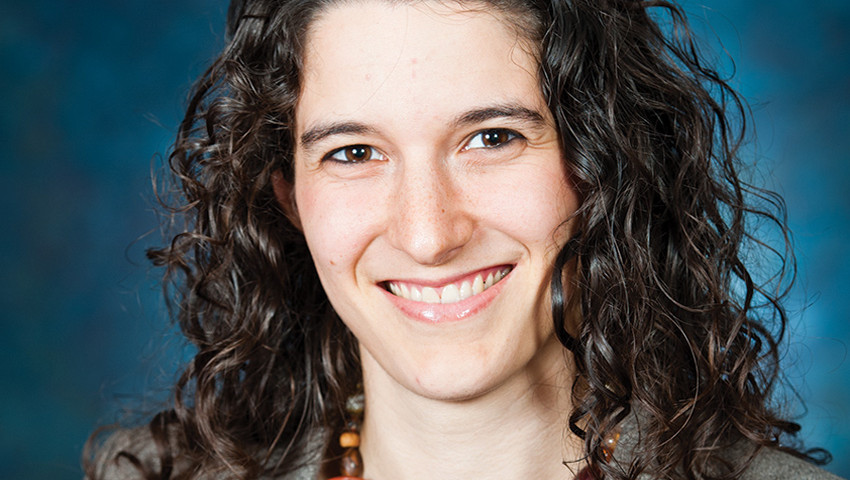 A woman with curly hair smiling for the camera.