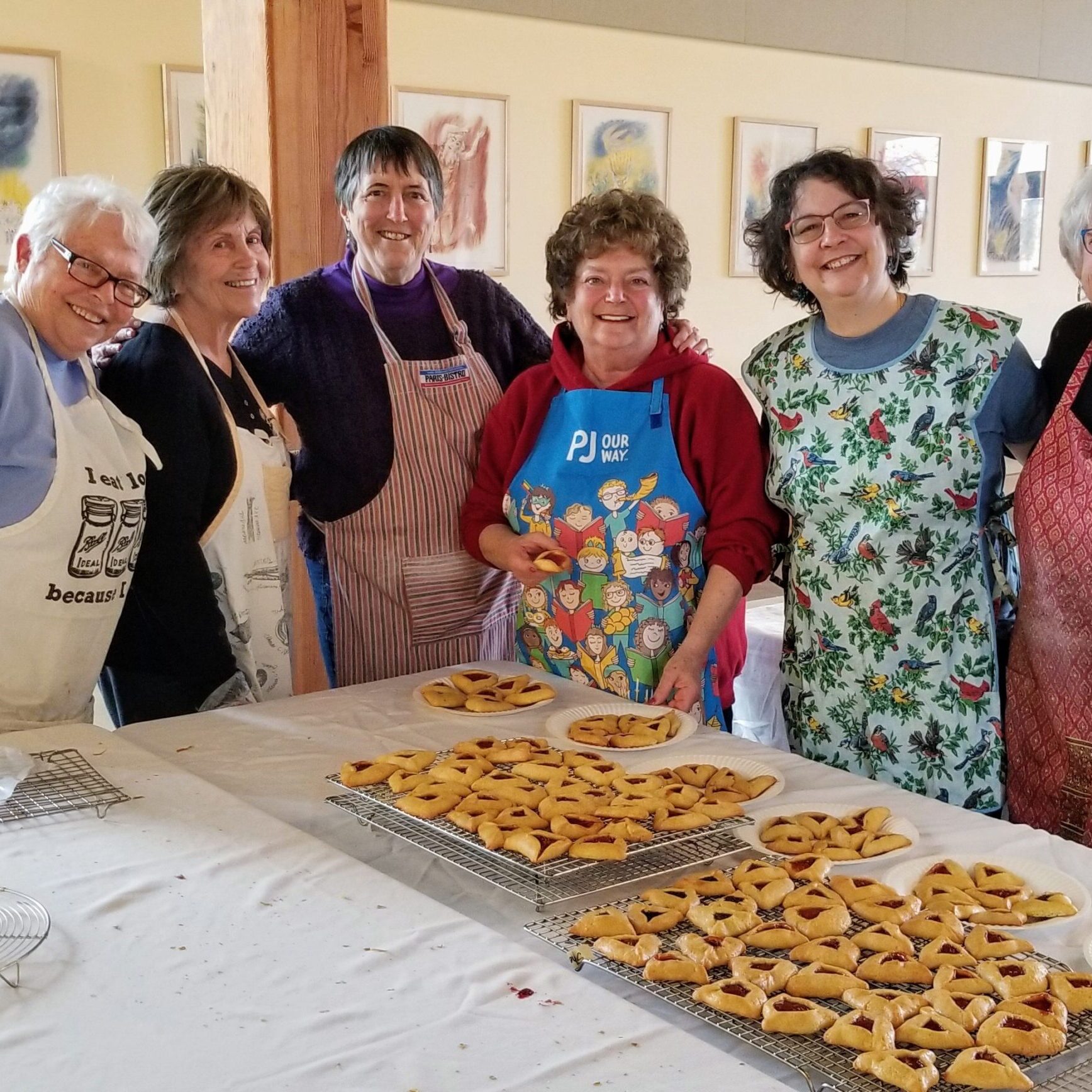 A group of people standing around a table with food.