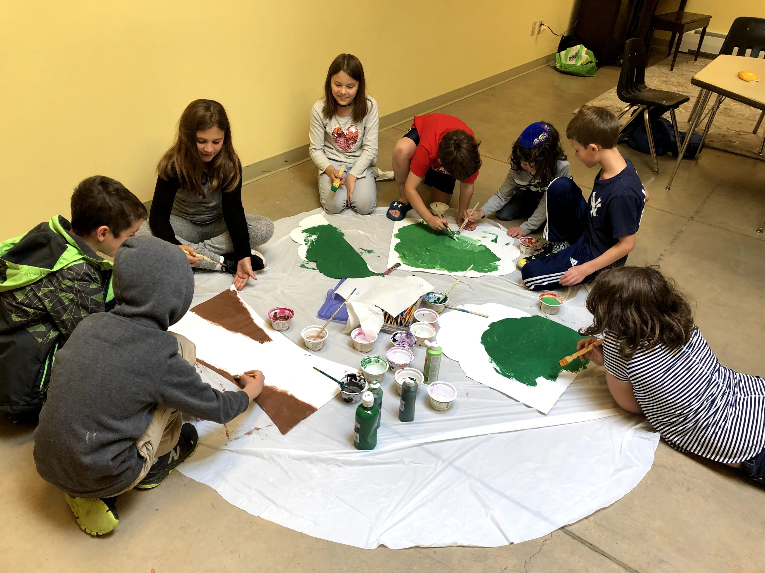 A group of children sitting around a table making paper.