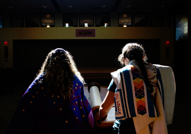 Two women holding hands in a room with lights.