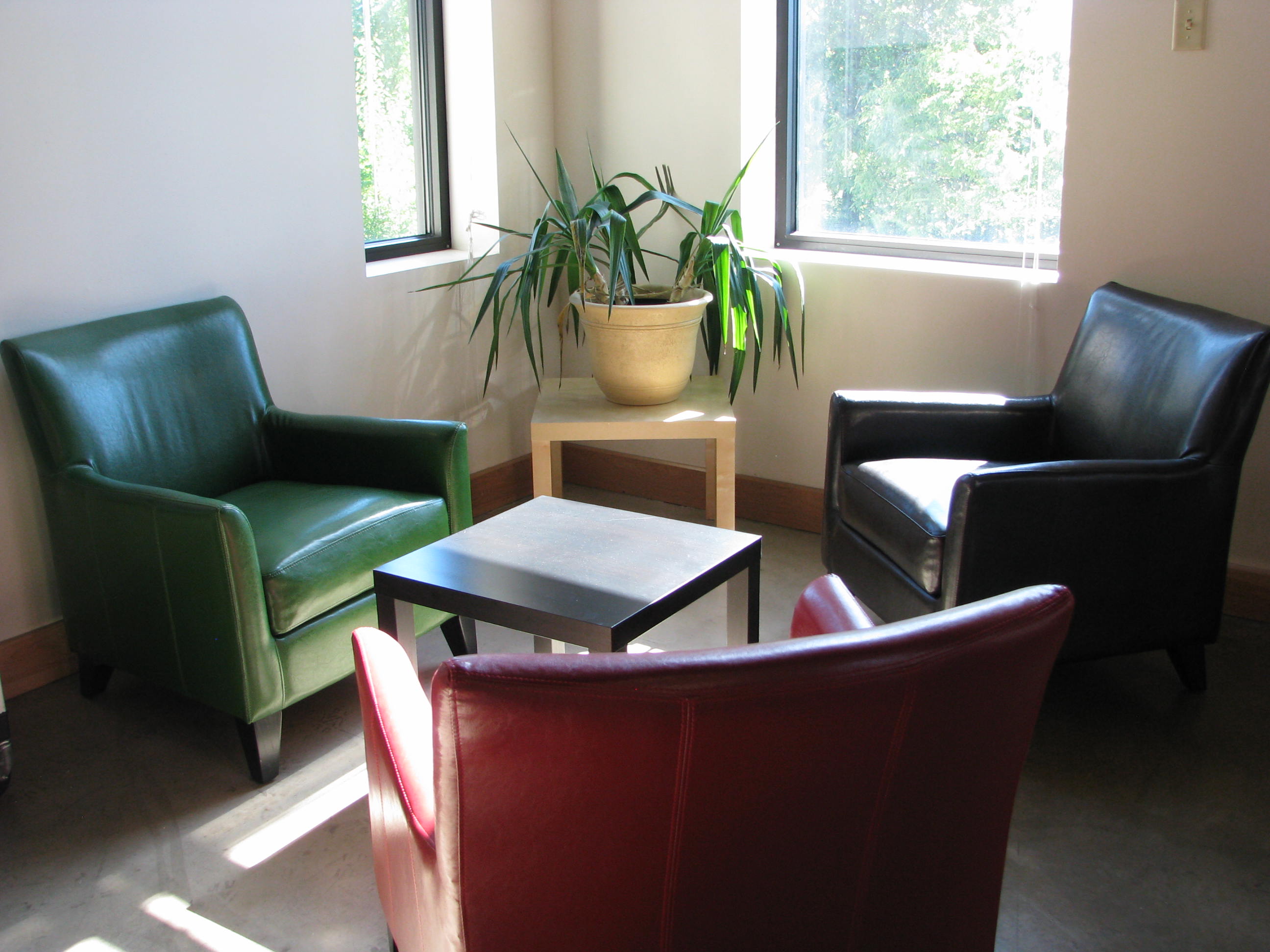 A group of chairs and a table in a room with a window.