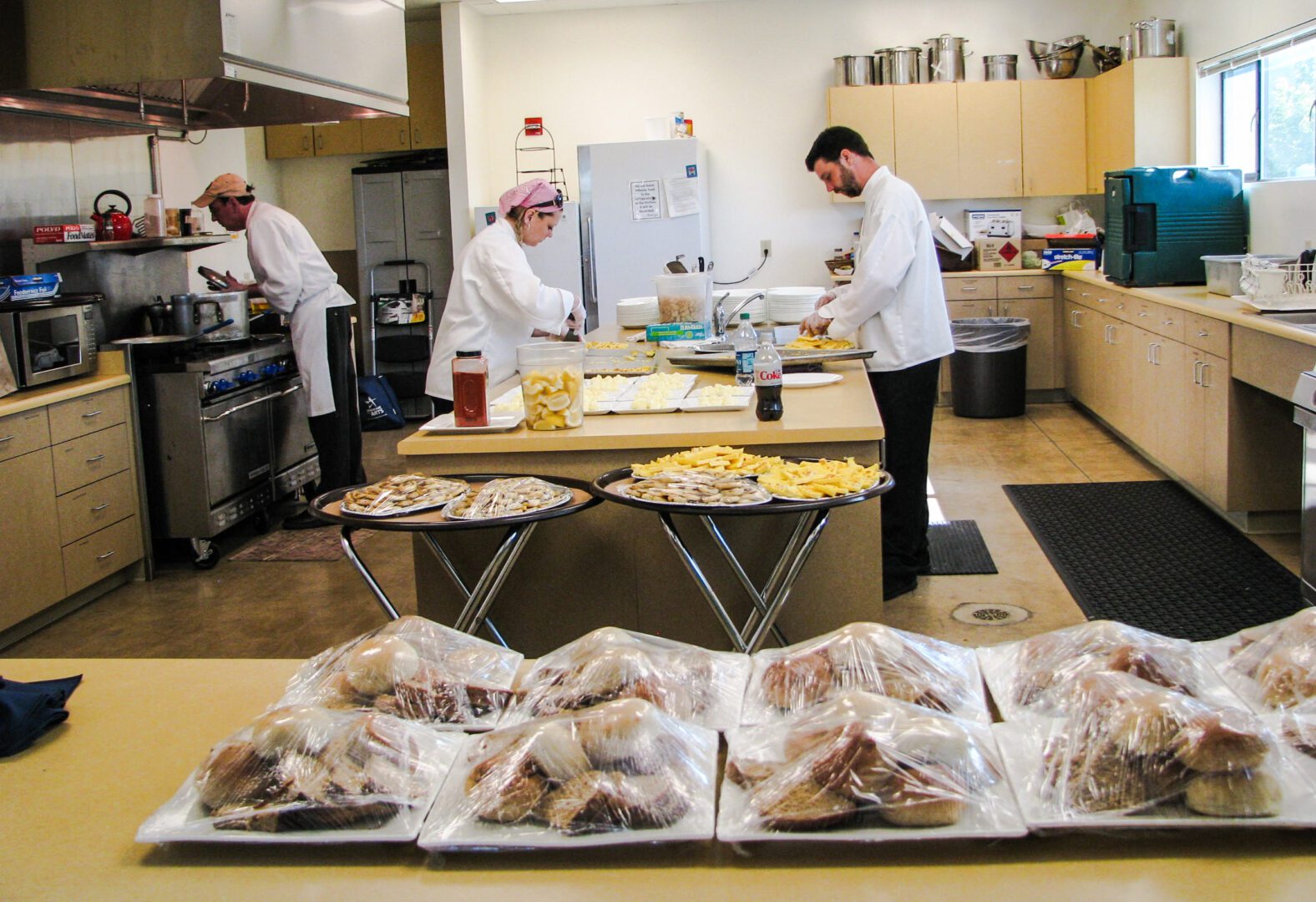 A group of people preparing food in a kitchen.