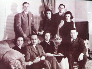 A group of people posing for a picture on a couch.