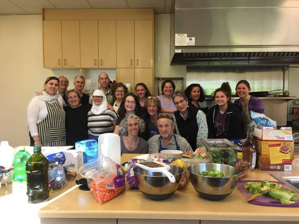 A group of people posing for a photo in a kitchen.