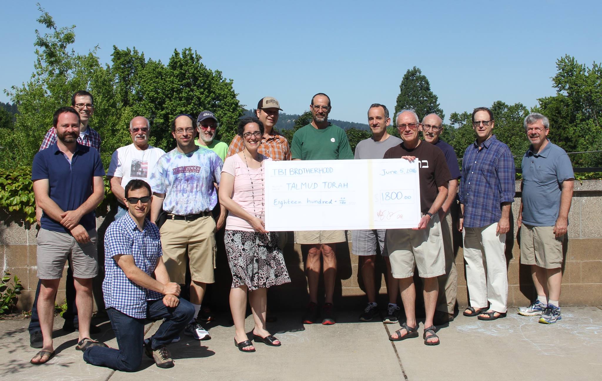 A group of people posing for a picture with a check.