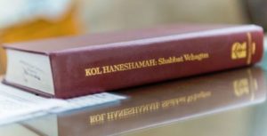 A book with a title of Kol Haneshamah kept on a table