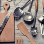 A group of kitchen utensils on a wooden table.