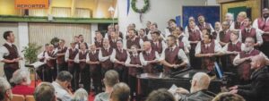 A choir of men standing in front of a piano.
