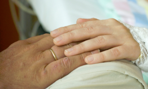 A close up of two hands with wedding rings on