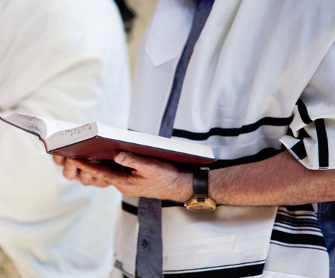 A man in white shirt and tie holding book.