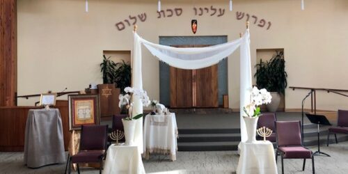 A wedding ceremony with white drapes and chairs.