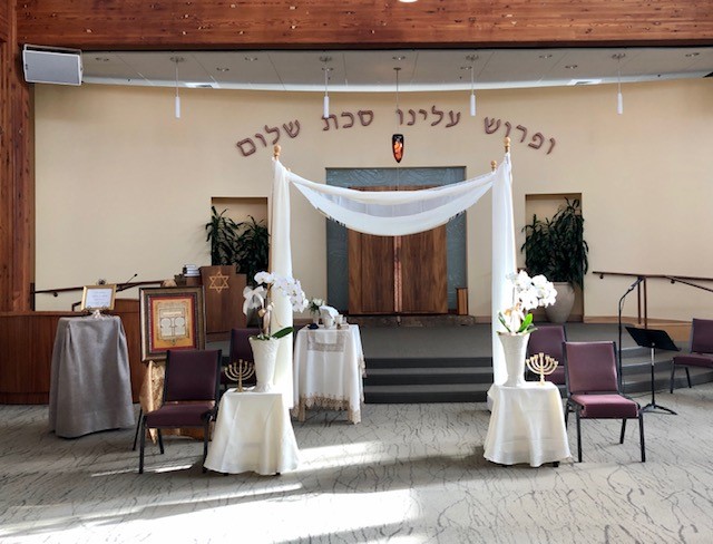 A wedding ceremony with white drapes and chairs.