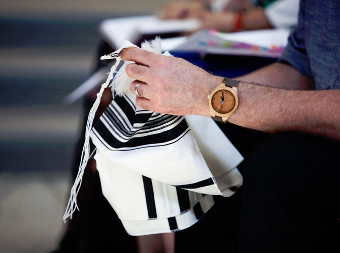 A person holding a bag and wearing a watch.