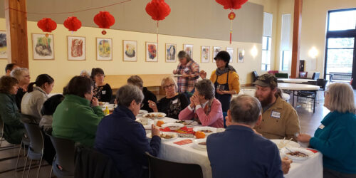 A group of people sitting at a table eating food.