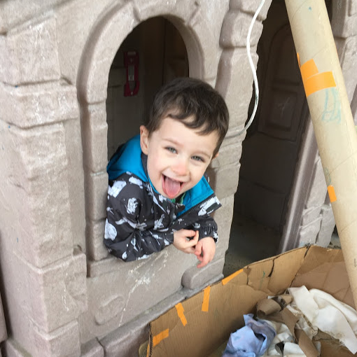 A young boy is smiling in the doorway of a castle.