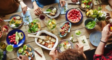 A group of people sitting around a table with food.