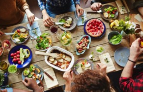 A group of people sitting around a table with food.