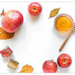 A white table topped with apples and honey.