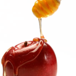 Apple-Honey A close up of an apple with honey being poured on it