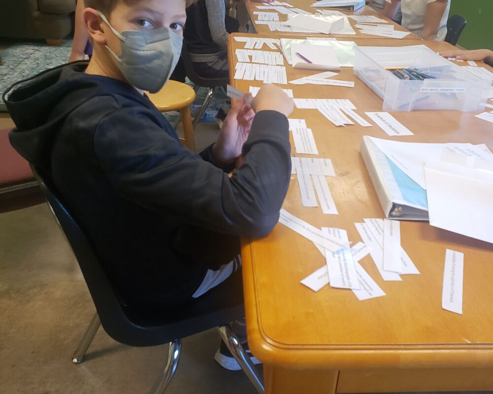 A group of people sitting at a table with papers on it.