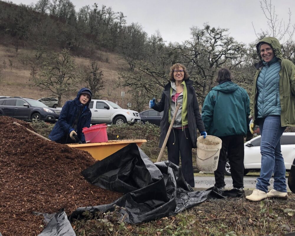 A group of people standing around some dirt