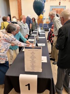 A group of people standing around a table.